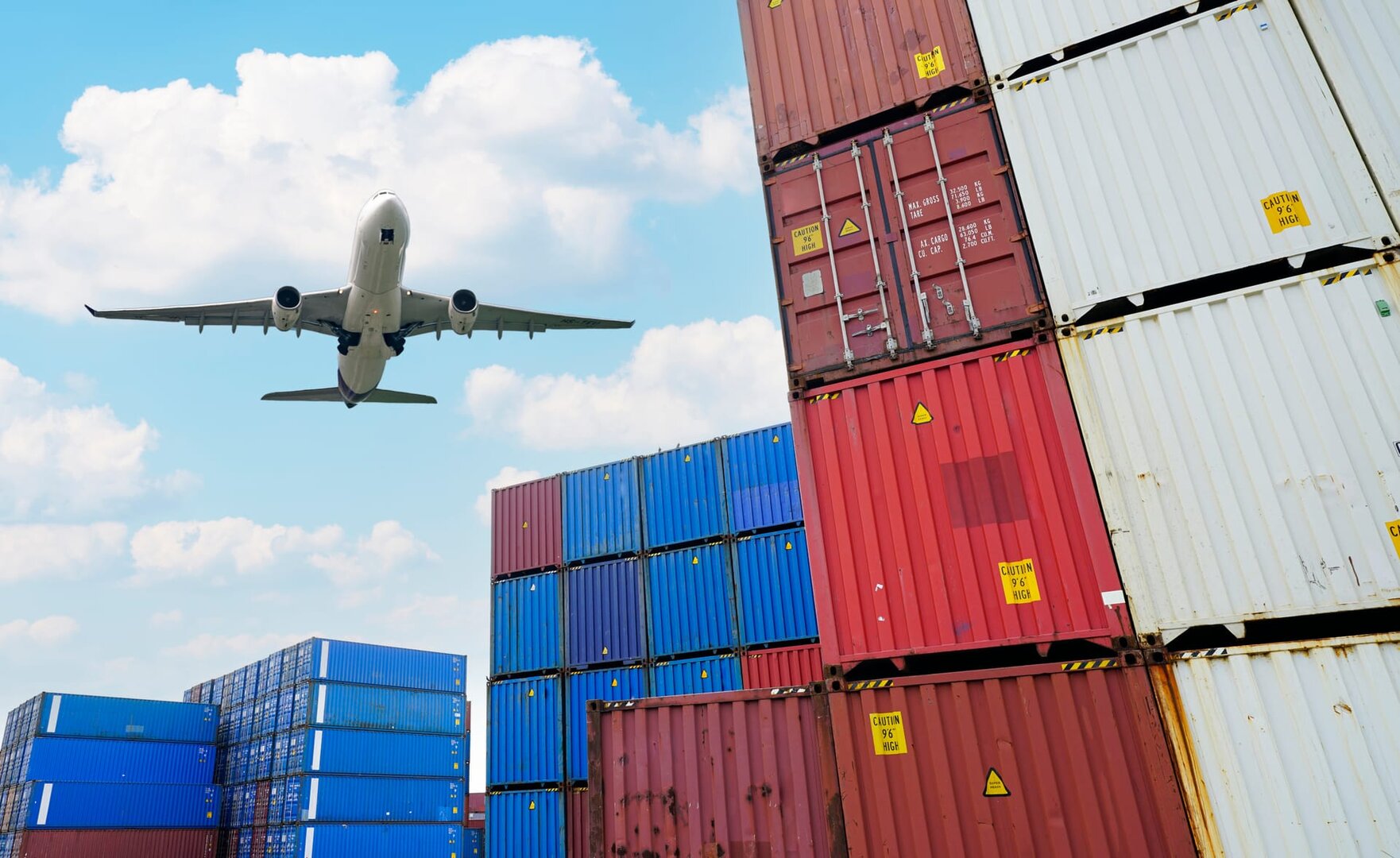 Aereo che decolla sopra pile di container
